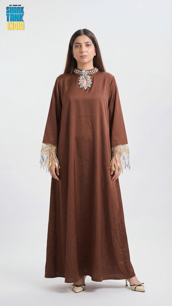 Woman wearing a brown dress with intricate detailing on a white background