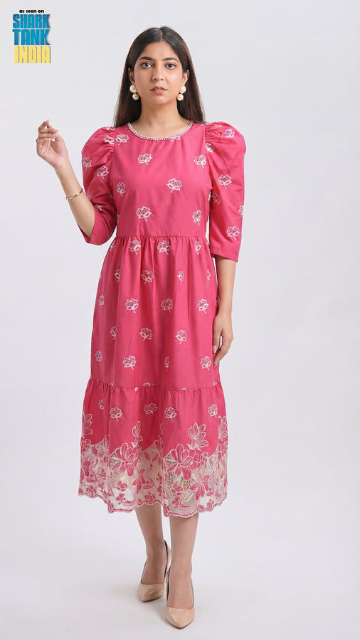 Woman wearing a pink dress with floral pattern on a white background