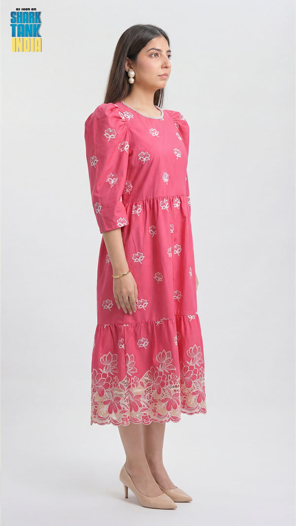 Woman wearing a pink dress with floral patterns on a white background