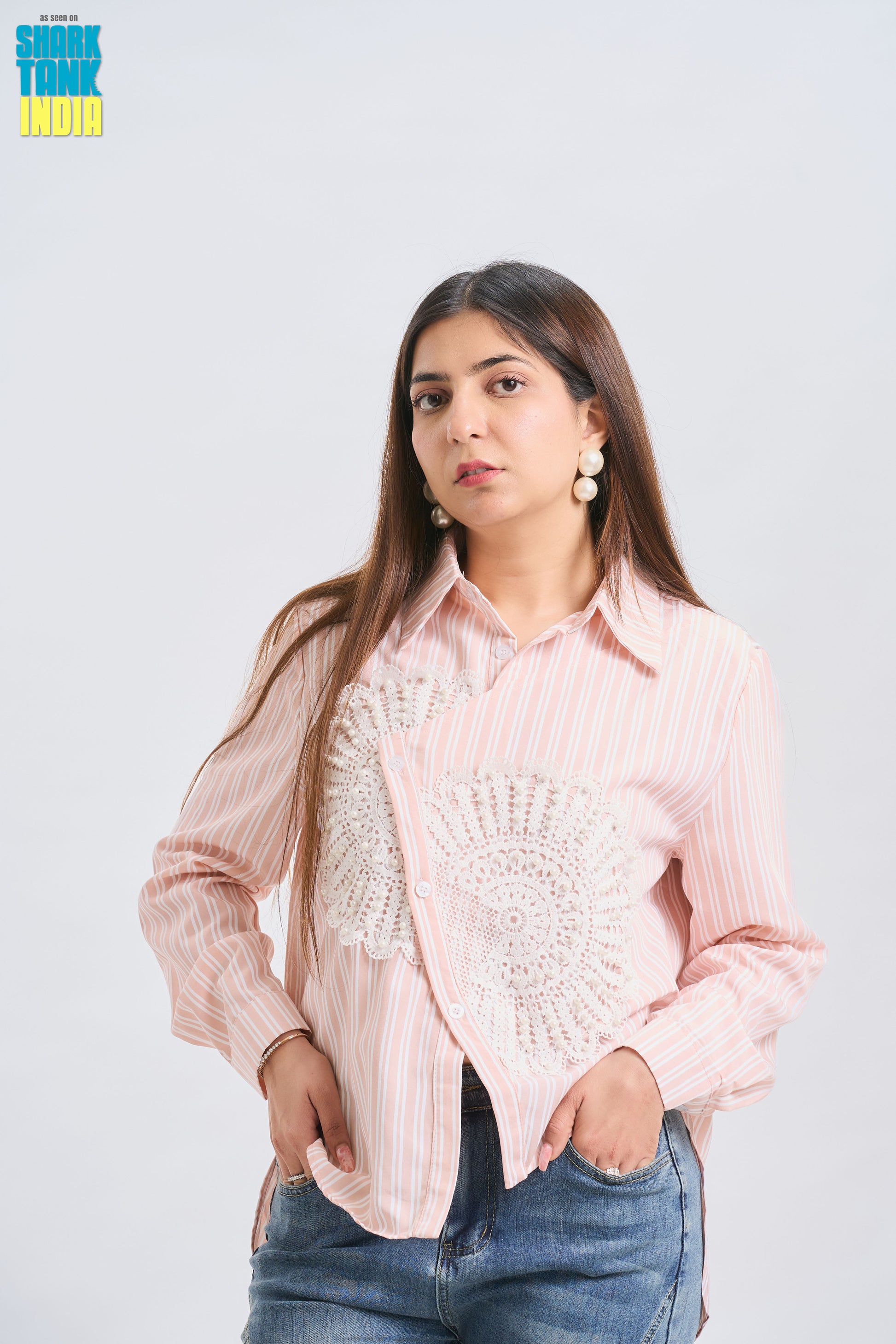 Woman wearing a light pink blouse with a textured design on a white background