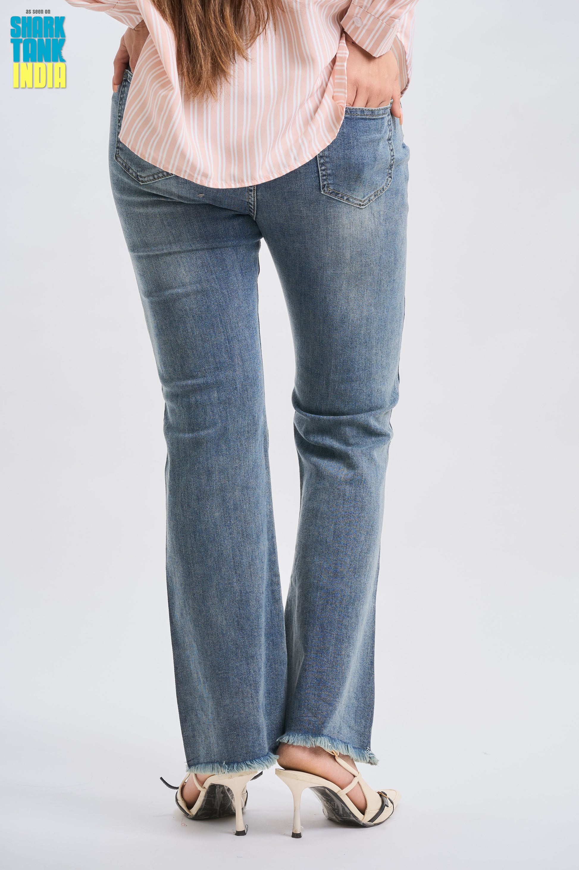 Person wearing blue jeans on a plain background
