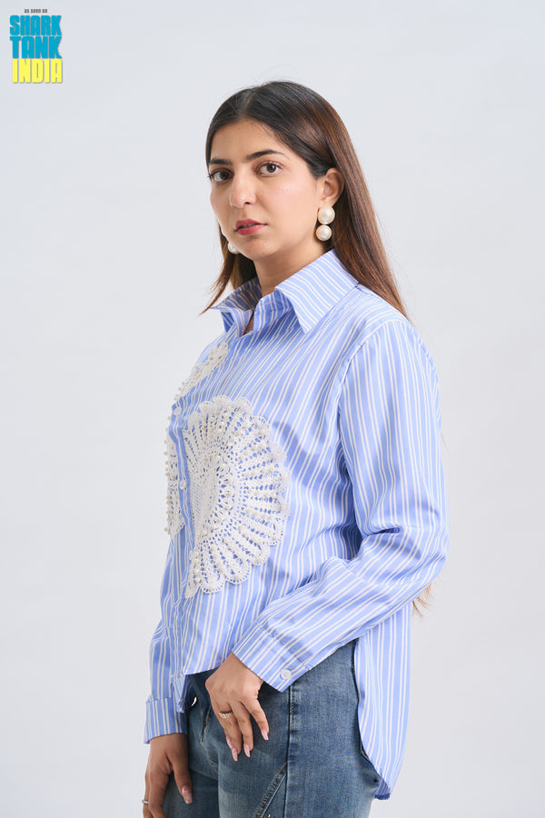 Woman wearing a blue striped shirt with decorative elements on a white background