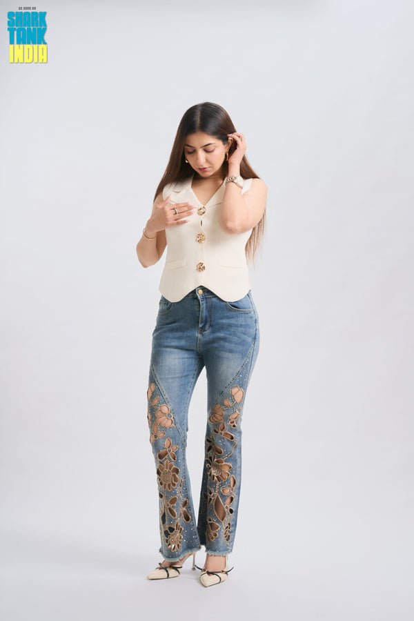 Woman wearing a cream top and distressed jeans on a white background