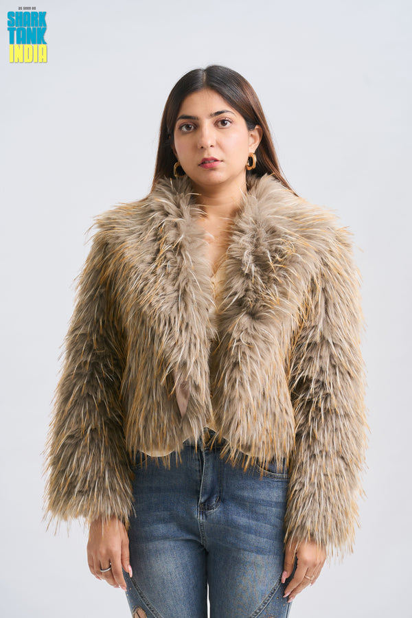 Woman wearing a fur coat and jeans against a white background