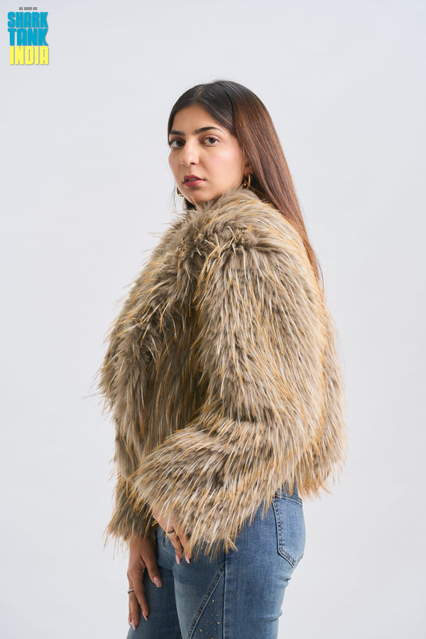 Woman wearing a fluffy beige jacket against a white background