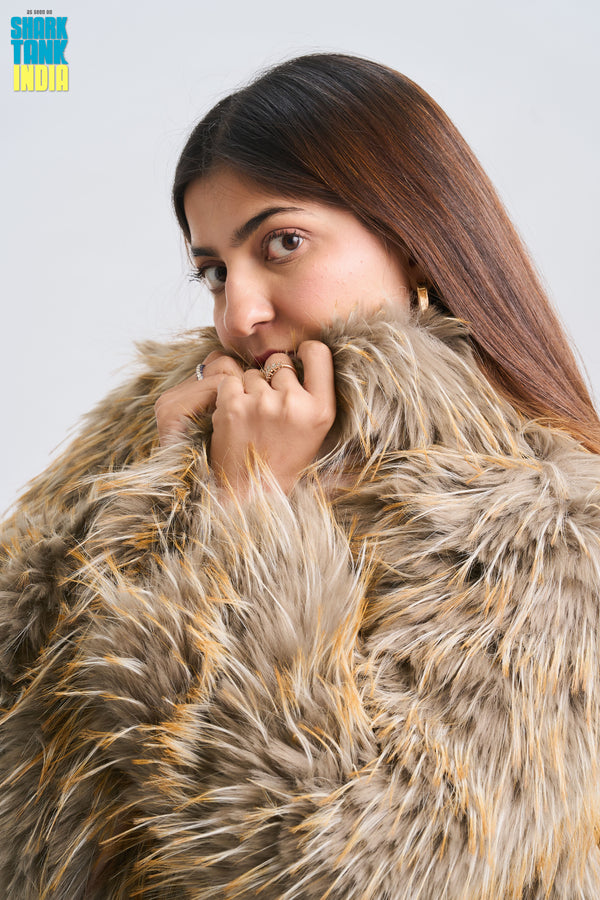 Woman wearing a fur coat against a plain background