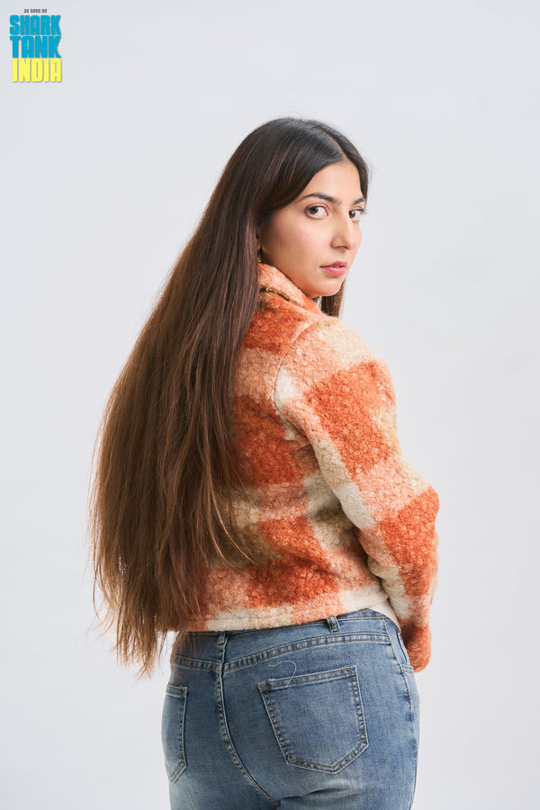 Woman wearing a patterned sweater and jeans on a white background