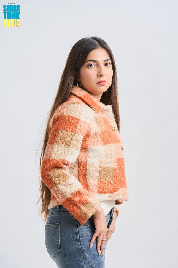 Woman wearing a plaid jacket with a neutral background