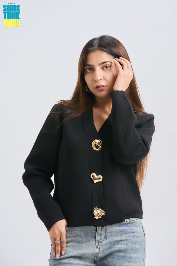 Woman wearing a black blazer with gold buttons on a white background
