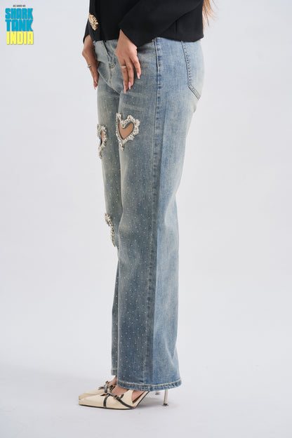 Light blue jeans with heart cutout design worn by a person on a white background