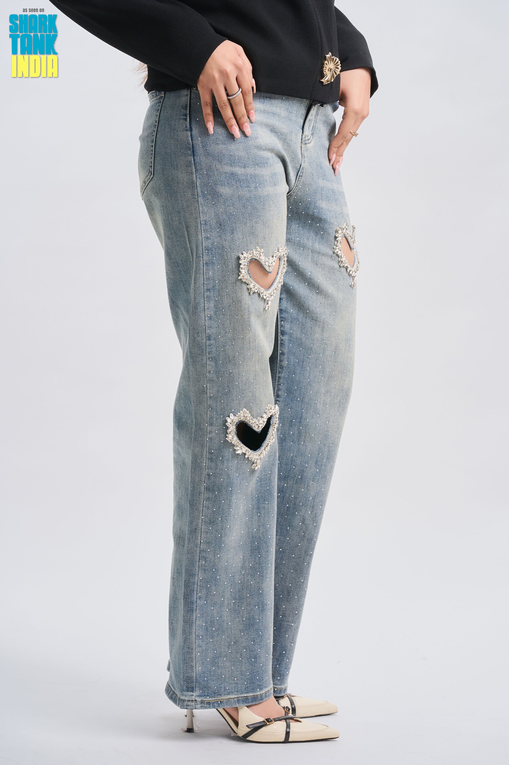 Ripped jeans with heart shapes on a plain background