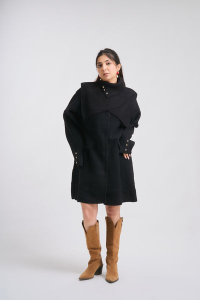 Person wearing a black coat and brown boots on a white background