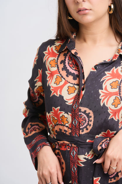 Woman wearing a patterned shirt with a plain background