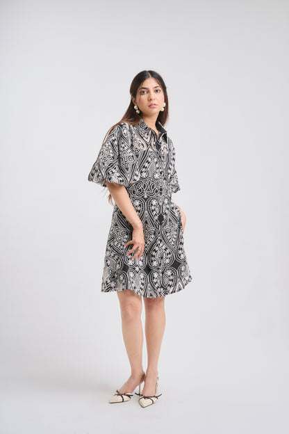 Woman wearing a black and white patterned dress on a white background