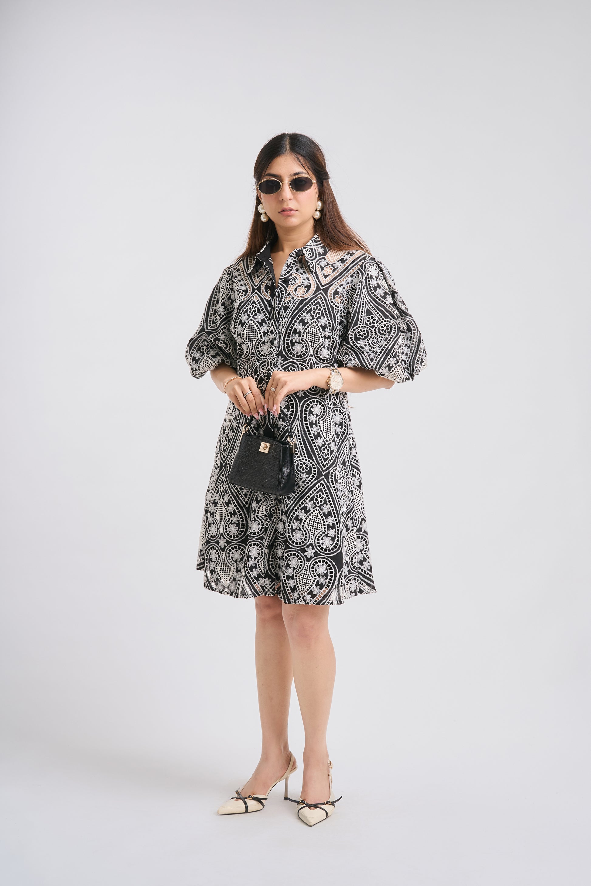 Woman wearing a black and white patterned dress on a white background