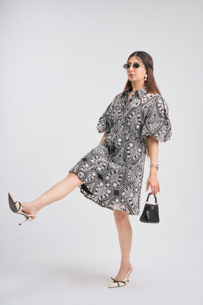 Woman wearing a black and white patterned dress on a white background