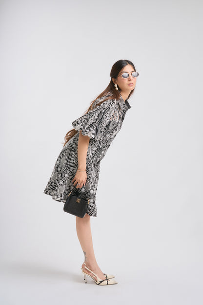 Woman wearing a black and white patterned dress on a white background