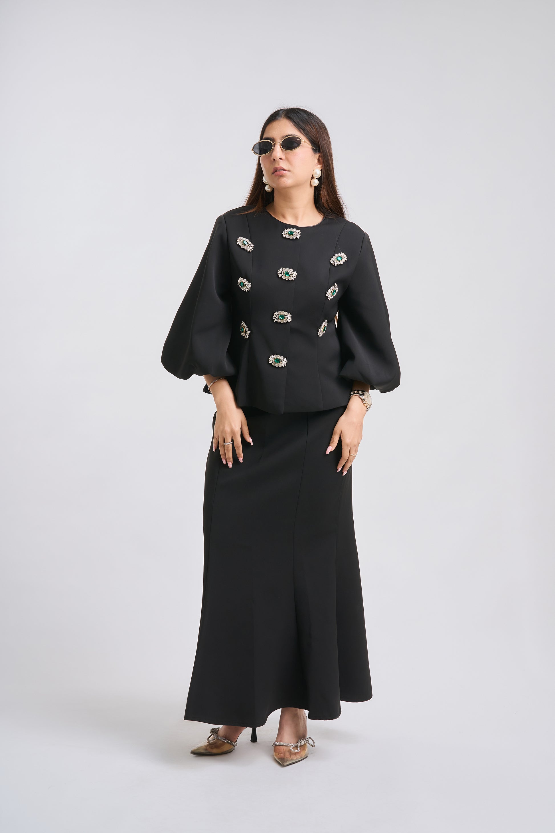 Woman wearing a black outfit with decorative elements on a white background