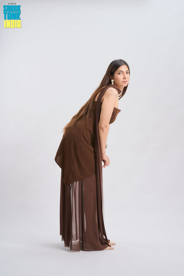 Woman wearing a brown dress with sheer overlay on a white background