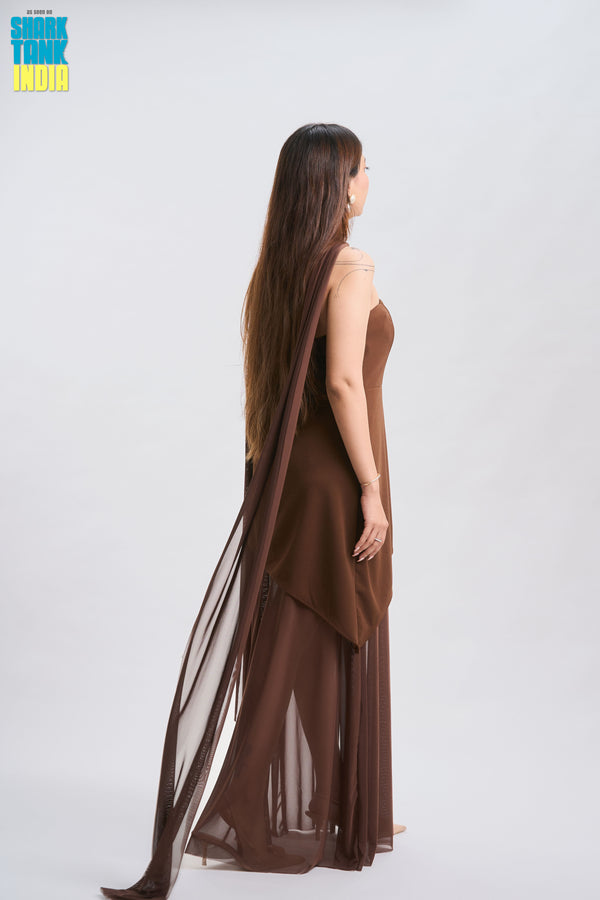 Woman wearing a brown dress with sheer overlay on a white background