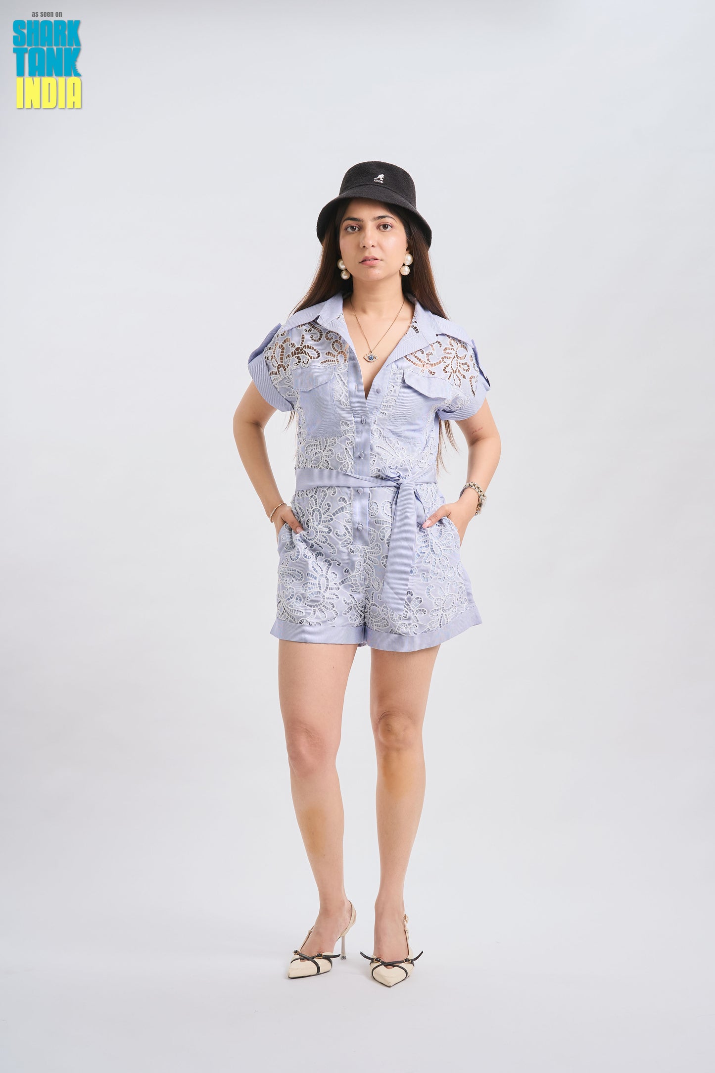 Woman wearing a light blue outfit with a hat on a white background