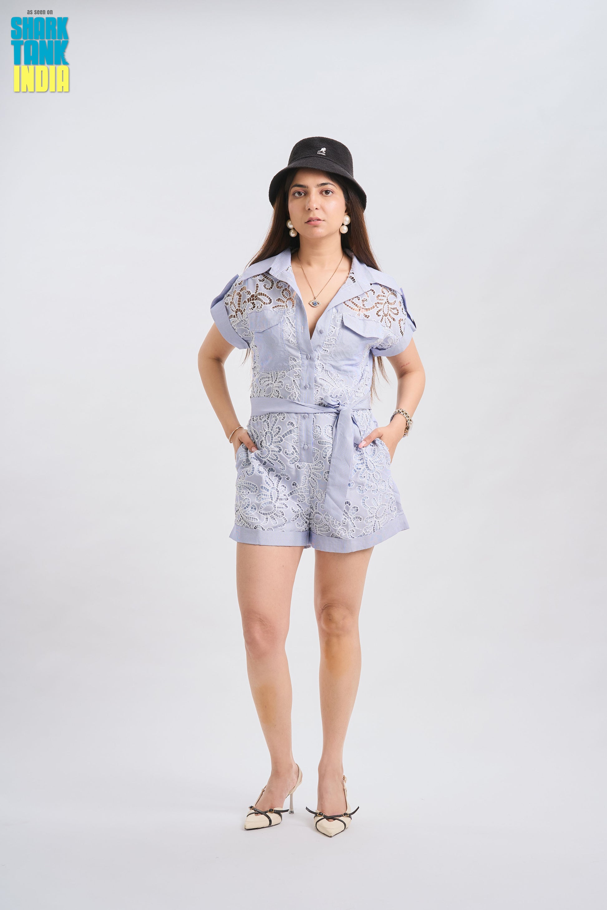 Woman wearing a light blue outfit with a hat on a white background