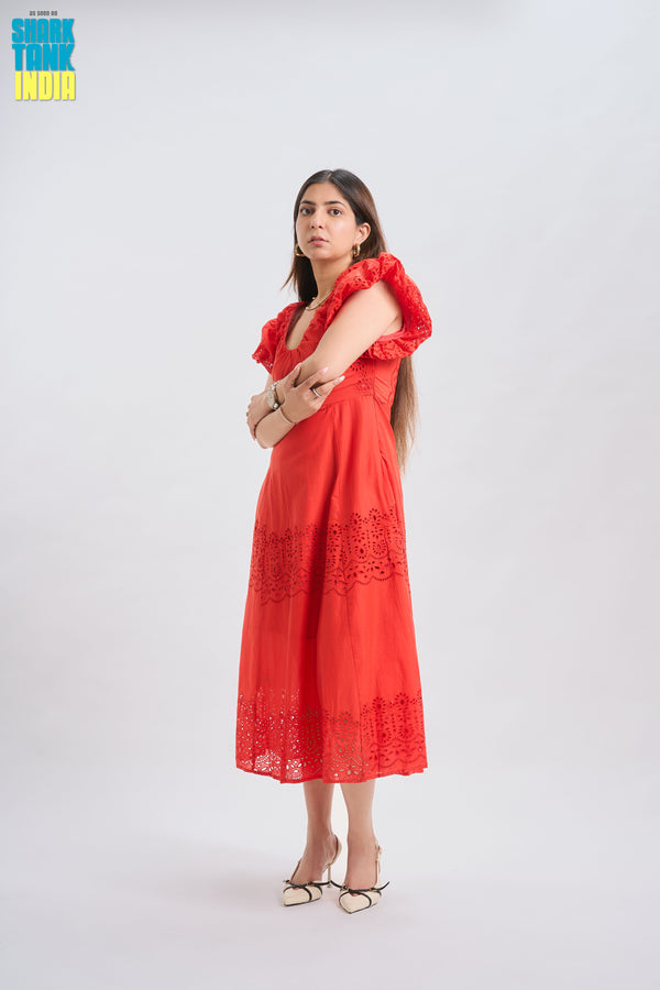 Woman wearing a red dress with ruffled sleeves on a white background