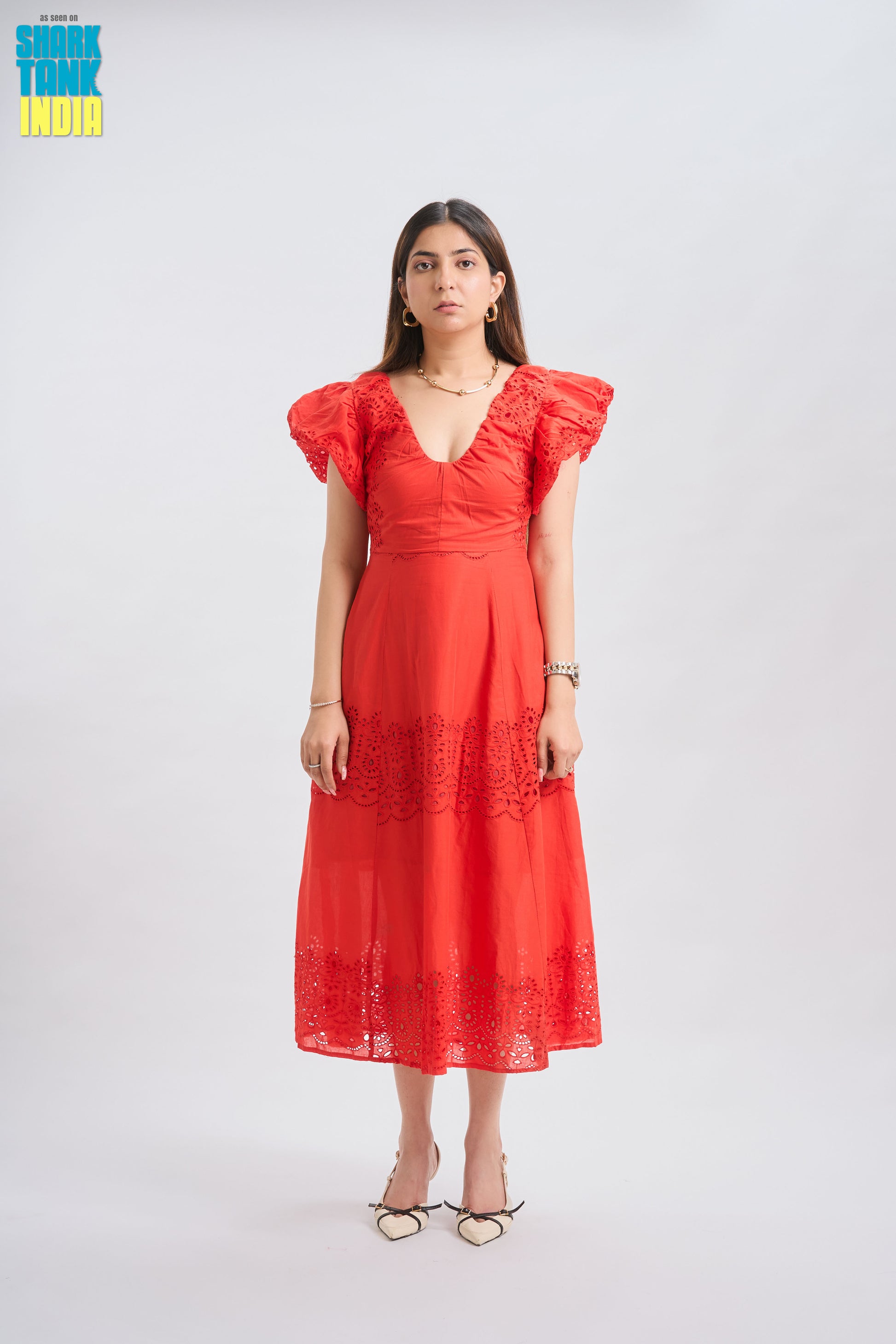 Woman wearing a red dress with ruffled sleeves on a white background