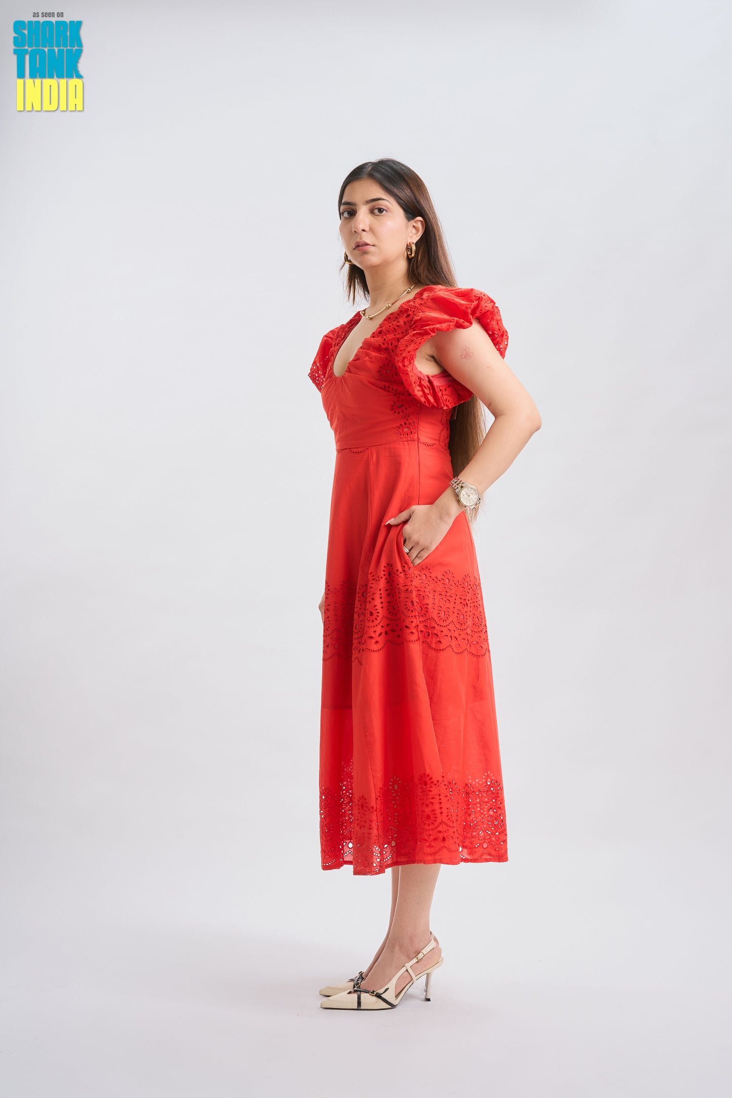 Woman wearing a red dress with ruffled sleeves on a white background