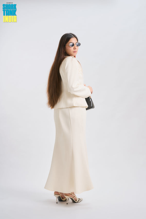 Woman in a white suit standing against a white background