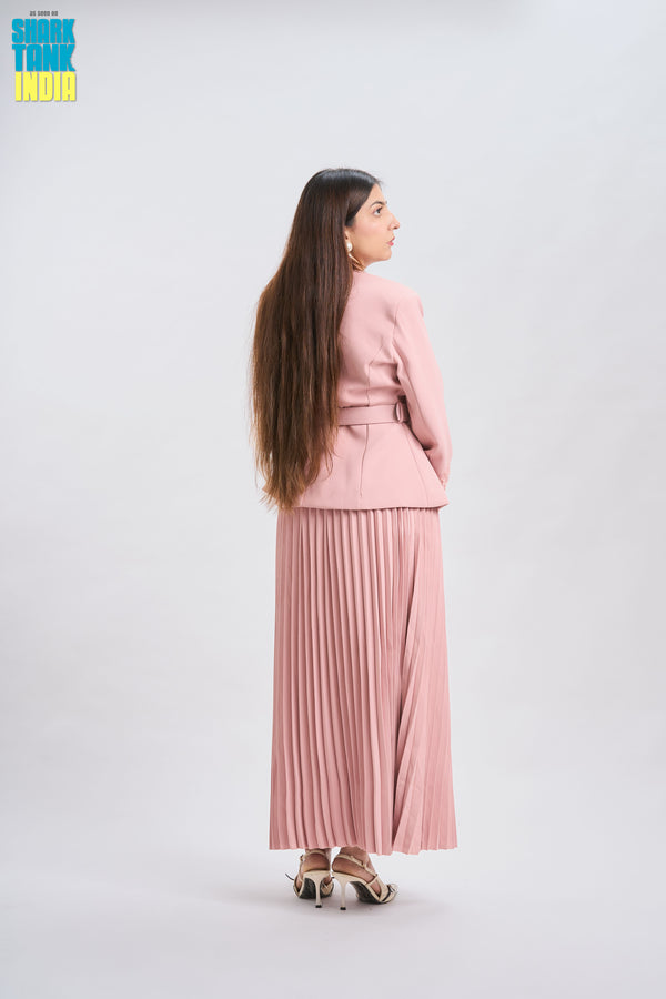 Woman in a pink outfit standing against a white background