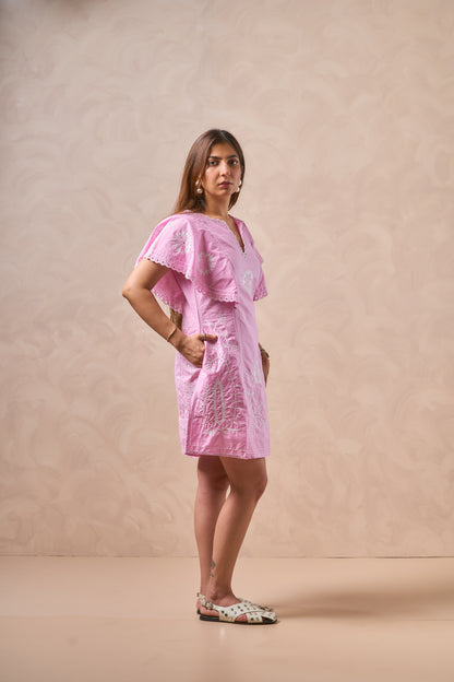 Woman wearing a pink dress against a beige background