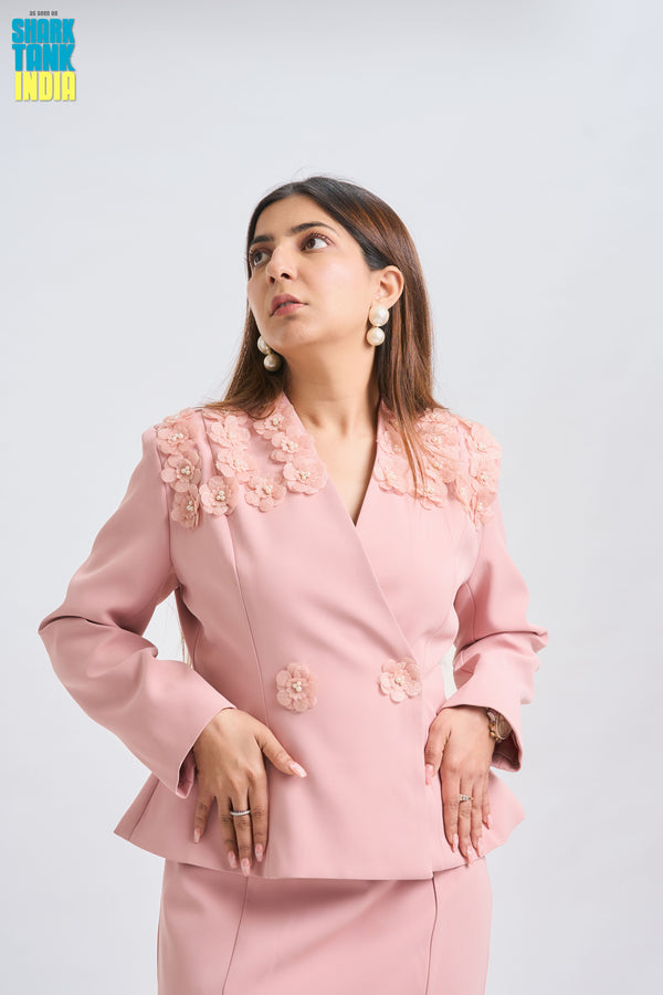 Woman wearing a pink outfit with floral details on a white background