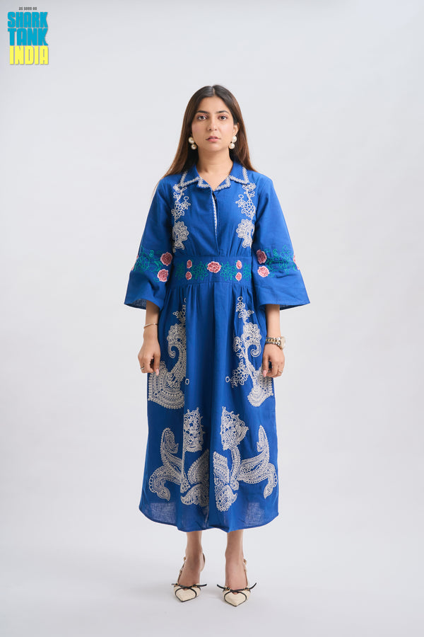 Woman wearing a blue embroidered dress on a white background