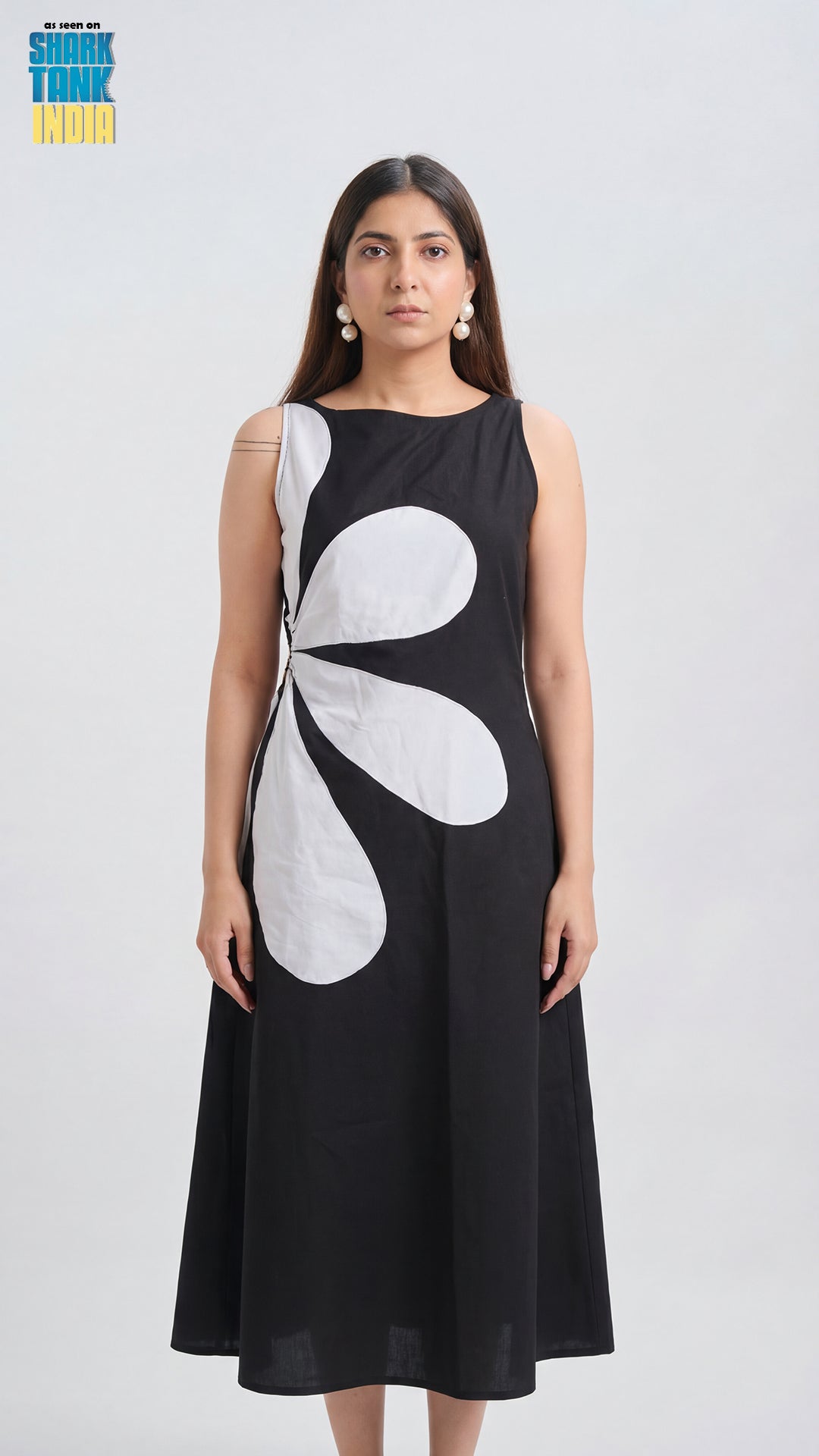 Woman wearing a black dress with a white abstract design on a white background