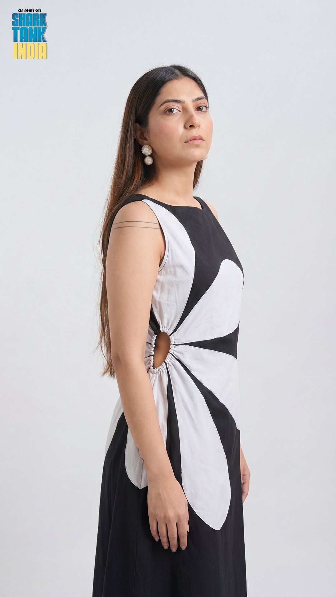 Woman wearing a black and white dress with floral design on a white background