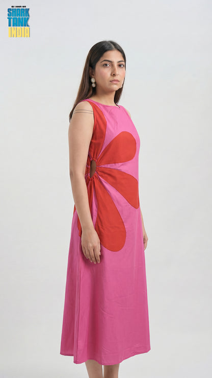 Woman wearing a pink dress with a red abstract design on a white background