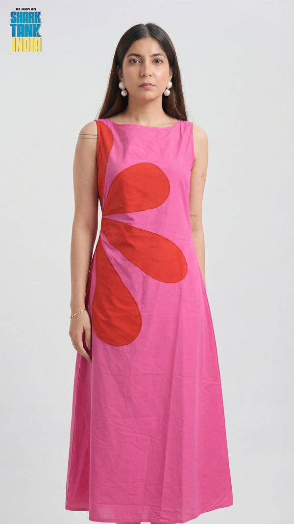 Woman wearing a pink dress with red floral patterns on a white background