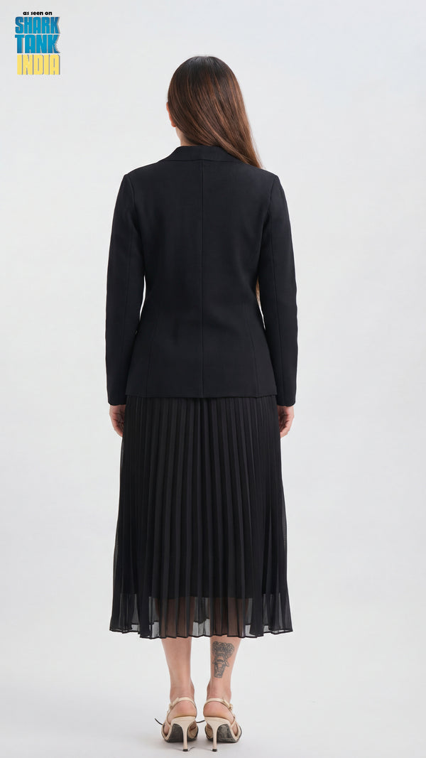 Woman wearing a black outfit with a pleated skirt on a white background