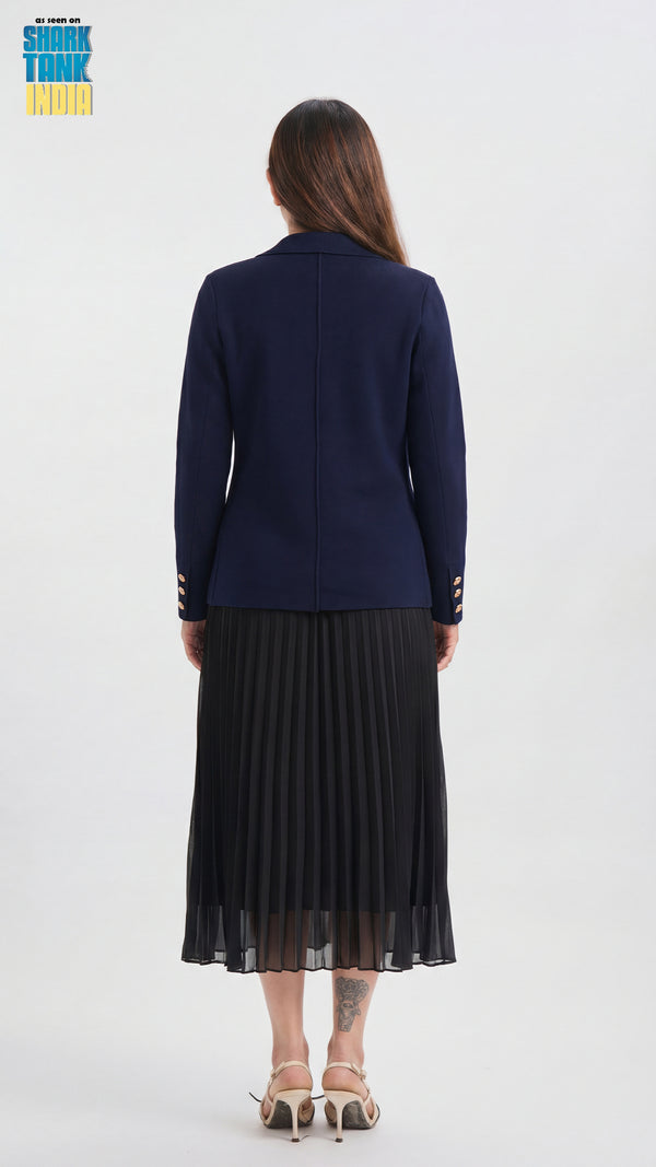 Woman wearing a navy blue cardigan and black pleated skirt on a white background