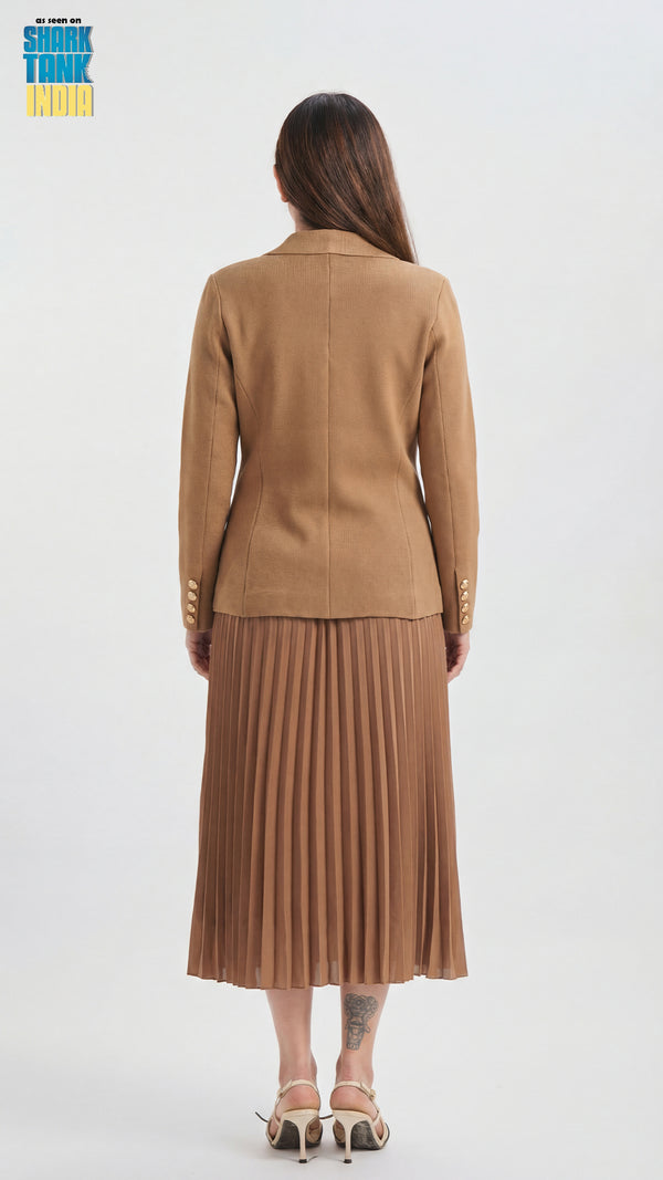 Woman wearing a brown suit with a pleated skirt on a white background