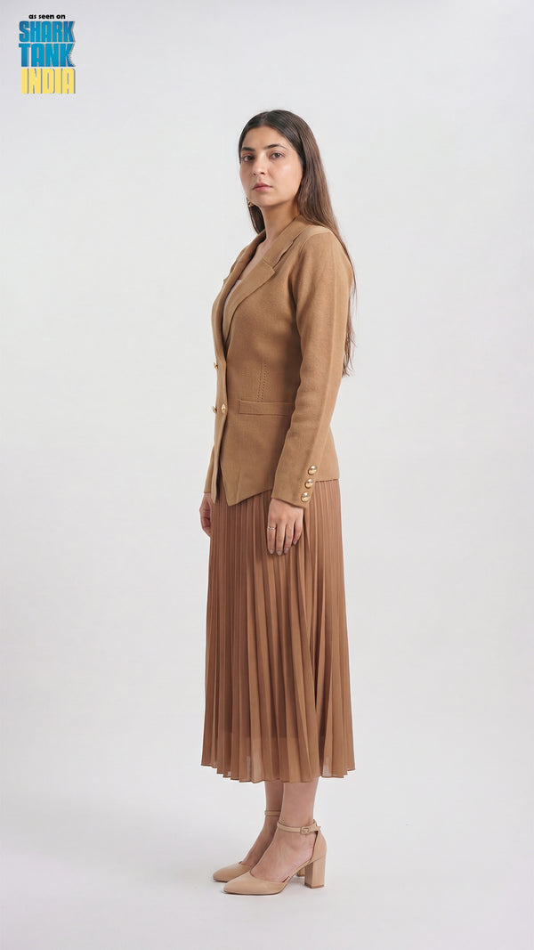 Woman wearing a brown suit with a pleated skirt on a white background