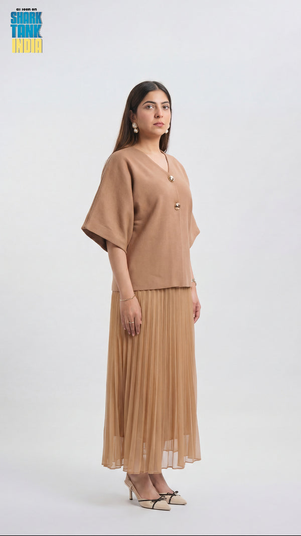 Woman wearing a beige outfit with a plain background