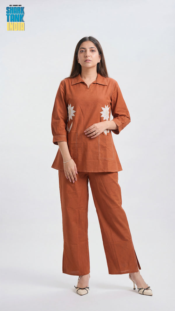 Woman wearing a brown outfit with floral patterns on a white background