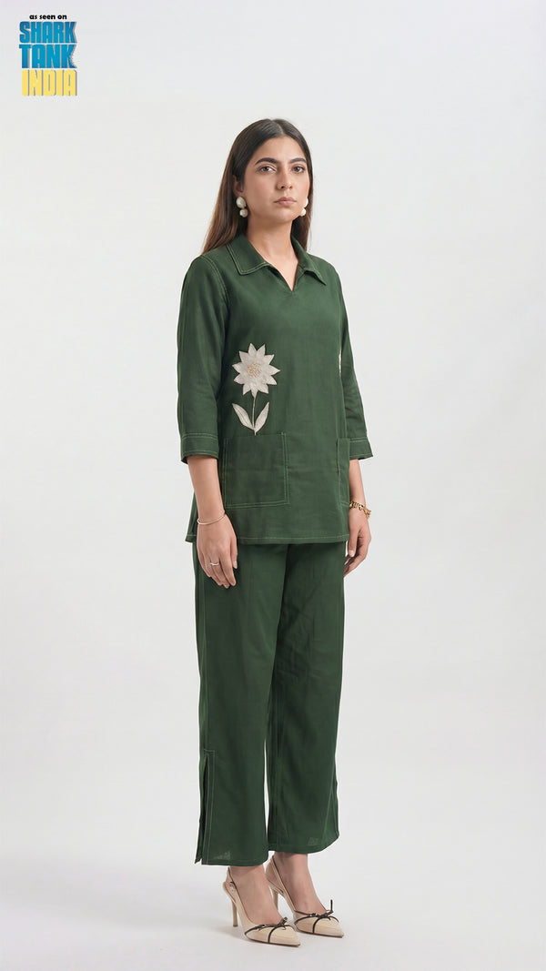 Woman wearing a green outfit with floral details on a white background