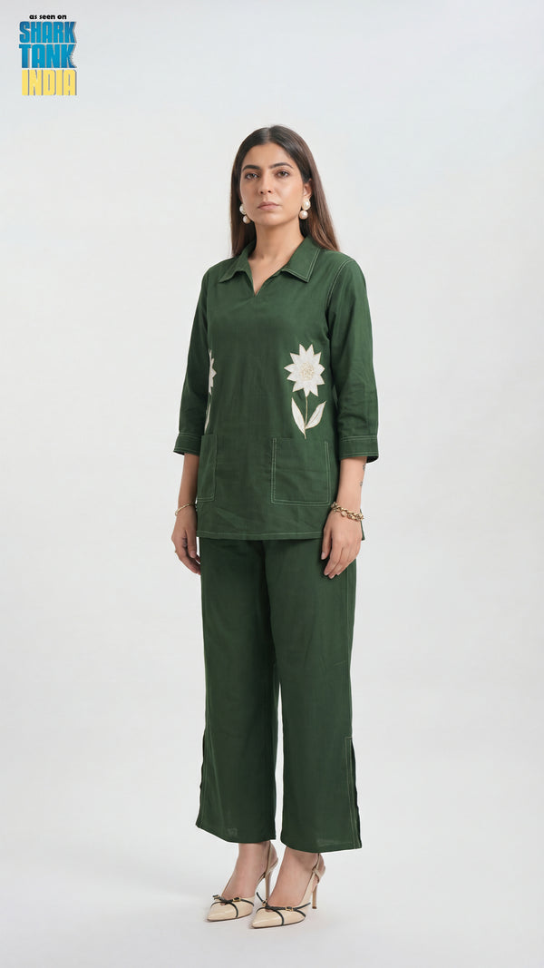 Woman wearing a green outfit with floral design on a white background