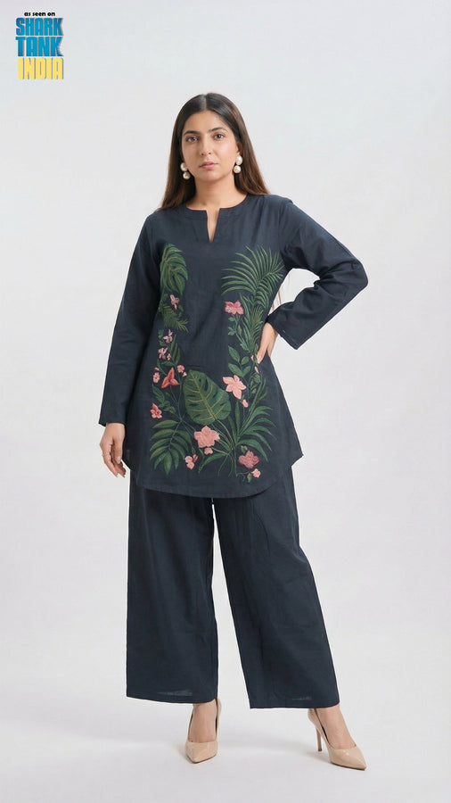 Woman wearing a dark blue outfit with floral embroidery on a white background