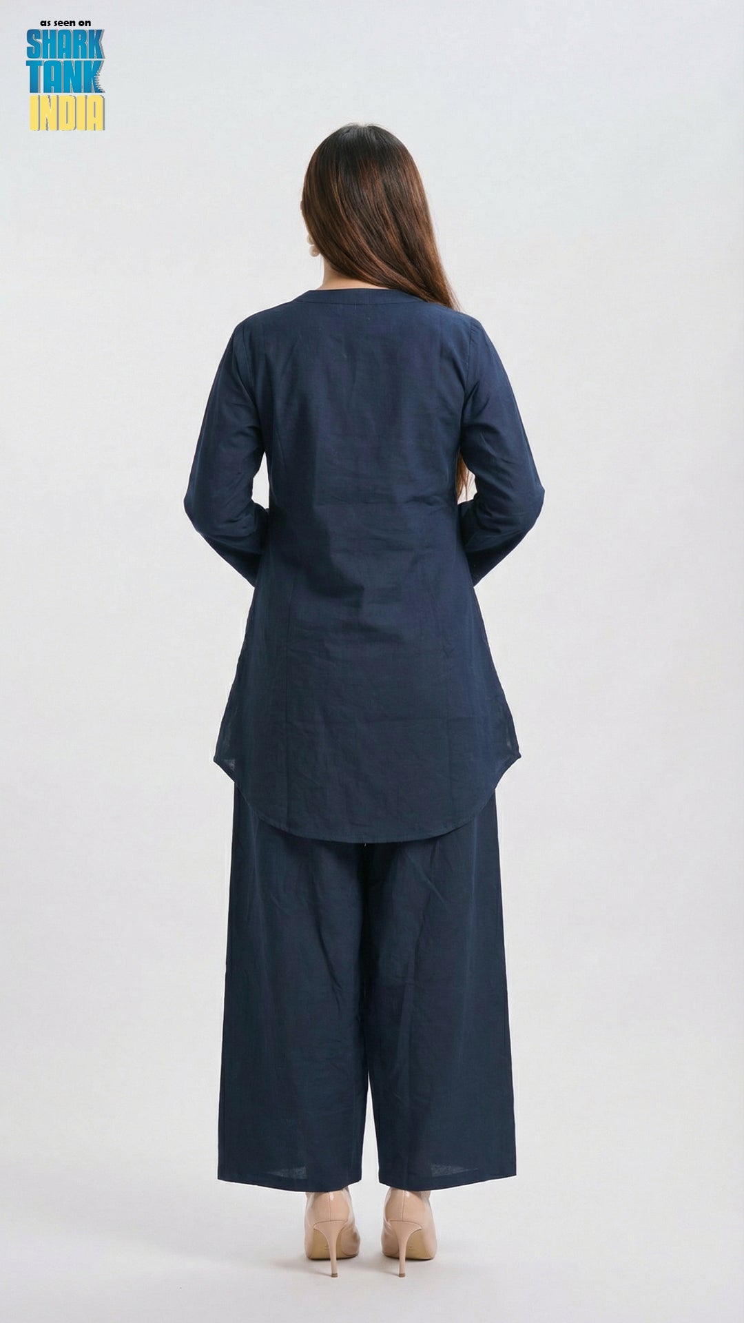 Woman wearing a navy blue outfit with wide-leg pants on a white background