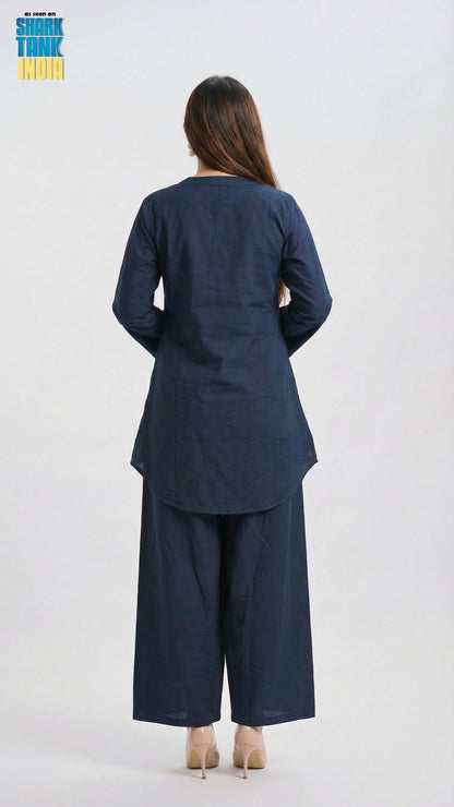 Woman wearing a navy blue outfit with wide-leg pants on a white background