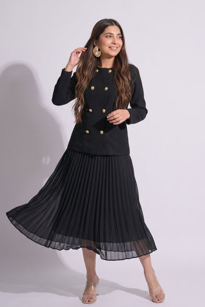 Woman wearing a black outfit with a jacket and pleated skirt on a white background